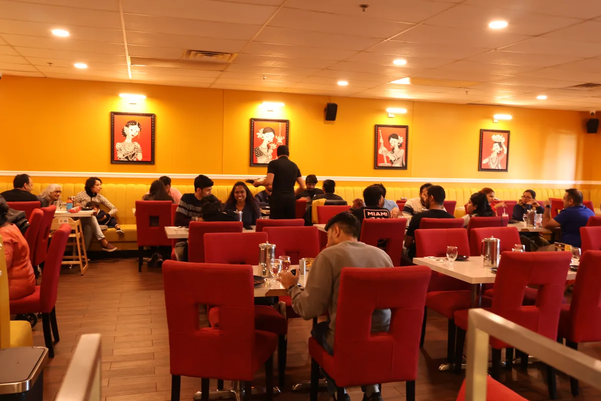 Guests dining in the vibrant main dining room at Mejwaani, best Indian restaurant in Edison NJ