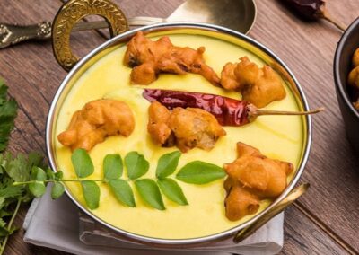 Kadhi Pakoda - Kadhi pakora is a delectable Indian dish where deep-fried pakoras made from a batter of gram flour and various spices are simmered in a spiced and tangy tomato-based gravy.